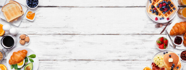 Leinwandbilder - Breakfast or brunch double border on a white wood banner background. Above view. Collection of sweet and savory food items.