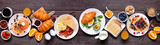Fototapeta Uliczki - Breakfast or brunch table scene on a dark wood banner background. Top view. Assortment of sweet and savory food items.