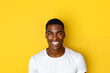 Portrait of handsome young black man against yellow background.
