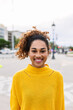 © Xavier Lorenzo - Joyful latin american teen girl smiling at camera outdoors. Portrait of young multiracial woman over urban background