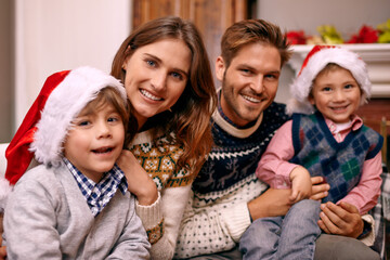 Wall Mural - Christmas, portrait and happy family in home for holiday or festive celebration in lounge. Xmas, parents and face of children with hats in living room, bonding and kids together at party in house