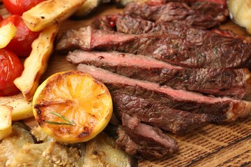 Wall Mural - Delicious grilled beef with vegetables and lemon on table, closeup