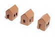 3 simple cardboard homes on white background