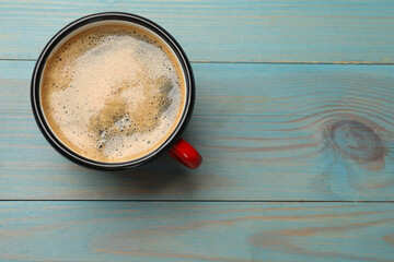 Wall Mural - Cup of aromatic coffee on light blue wooden table, top view. Space for text