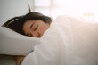 © Sevendeman - Close up of asian Thai woman closing eyes, sleeping on white bed with white blanket covering in the morning at room apartment.