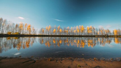 Wall Mural - Autumn Forest woods lake coast. Landscape Woodland Slider Time Lapse, Time-lapse. reflection on water surface wide angel, tranquil motion. Autumn River Landscape At Sunset.