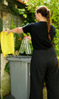 © Bruno - One person making a selective sorting of waste. A woman putting plastic bottles in a yellow bin for recycling.