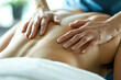 A close-up of a physiotherapist's hands manipulating the muscles of a patient's back during a therapeutic massage session.
