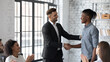 © fizkes - Good job. Friendly, smiling CEO thanking worker for excellent performance, quality results and enthusiastic attitude to work. Happy executive congratulating African-American employee with promotion