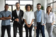 Group portrait of aspiring young coworkers. Confident start-up company employees at work standing together and looking at camera. Staff members of multinational organization in modern workspace