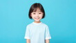 © Natalia - Young little asian girl posing on blue background mockup. Copy space.