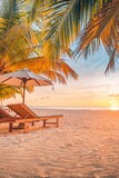 Fototapeta Panele - Beautiful tropical sunset coast, two sun beds chairs umbrella under palm trees. Closeup white sand, sea view horizon colorful twilight sky calm and relaxation. Inspire beach resort tourism landscape