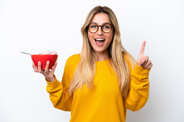 Wall Mural - Young Uruguayan woman holding a bowl of cereals isolated on white background pointing up a great idea