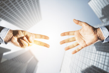 Close up of young businessmen hands playing rock paper scissors on bright light city buildings background. Leisure and game concept.