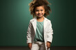 Young child wearing a doctor's white coat smiles sweetly at the camera.