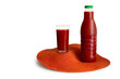 Close-up of a glass and bottle with red juice on a white background