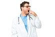 Brazilian doctor man over isolated chroma key background yawning and covering wide open mouth with hand