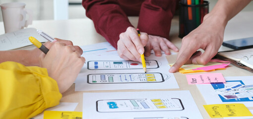 Wall Mural - close up of hands mobile phone app developer team meeting about screen display prototype layout for 