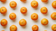 top down view of oranges evenly distributed on white background