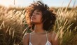 Young African-American woman with closed eyes standing among golden grass, basking in the warm glow of the sunset. The concept of tranquility and harmony with nature.