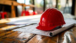 Red safety helmet for construction on blueprints, building concept