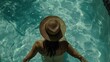 © ISK PRODUCTION - A woman wearing a hat sitting in a pool