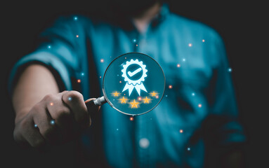 Fototapete - Businessman holding magnifier glass with correct certification symbol and five stars for quality assurance focus and product guarantee concept.