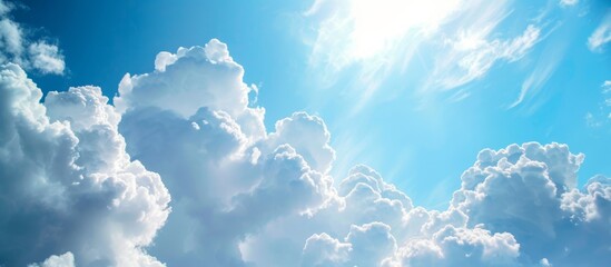 Wall Mural - vibrant blue sky with fluffy white clouds and shining sun in a peaceful summer day