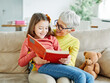 © Lumos sp - grandchild family child grandparent grandmother book reading elderly granddaughter girl  happy together read learning education woman