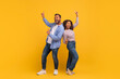 © Prostock-studio - Energetic young black couple dancing with joy, pointing fingers up