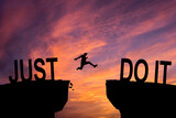 Fototapeta  - Man jumping on I can do it or I can't do it text over cliff on sunset background, Business concept idea.