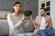 © Prostock-studio - Spouses in heated argument at home, sitting on sofa