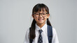 happy darkskinned schoolgirl teenager wearing eyeglasses on a gray solid background with copy space. 