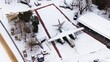 Snow-covered tanks, artillery, armored vehicles, military vehicles, and airplanes in Poznan Citadel during winter, captured by drone.