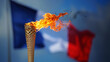 Olympic flame with the France flag in the background. Olympic games.