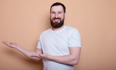 Wall Mural -  man with a beard is smiling and holding his hands up in the air. He is wearing a white shirt and he is posing for a picture