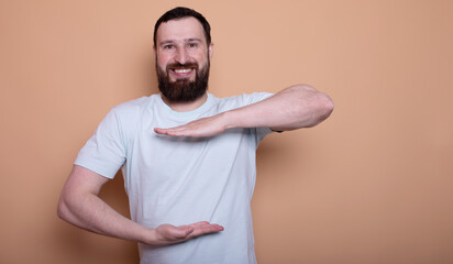 Wall Mural -  man with a beard is smiling and holding his hands up in the air. He is wearing a white shirt and he is posing for a picture