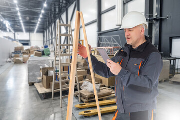 Poster - man builder. construction of industrial facilities. contractor guy is standing in hangar. man builde