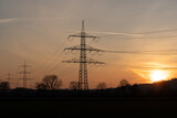 Fototapeta Łazienka - Silhouette of powerlines with the red glowing sun in the evening