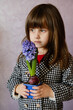 Little Girl holding hyacinth in flower pot.