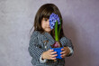 Little Girl holding hyacinth in flower pot. A beautiful little girl with blue hyacinth.