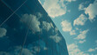 The glass exterior of a futuristic office building reflecting the clouds and sky.