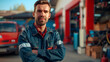 Portrait of attractive confident male auto car mechanic working in Car Service standing in front of car workshop. Working portrait concept