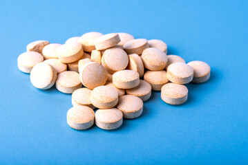 Orange pills vitamin C. pills on blue background.