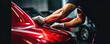 Car detailing close up.: man cleaning red sport car.
