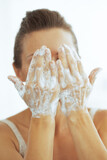 Fototapeta Paryż - Young woman washing face in bathroom