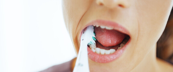 Wall Mural - Closeup on young woman brushing teeth