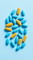 Wall Mural - Yellow and blue pills on blue background. Top view with copy space