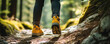 Detial of legs in hiking yellow shoes walking in the forest, using hiking sticks.