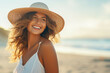 a smiling woman with a straw hat standing on the beach